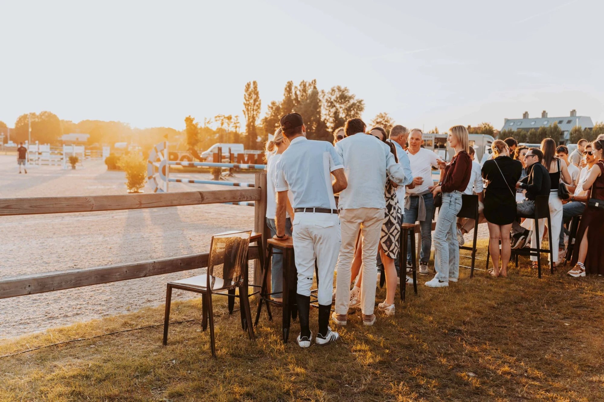 Gasten aan statafels langs een jumpingpiste bij zonsondergang