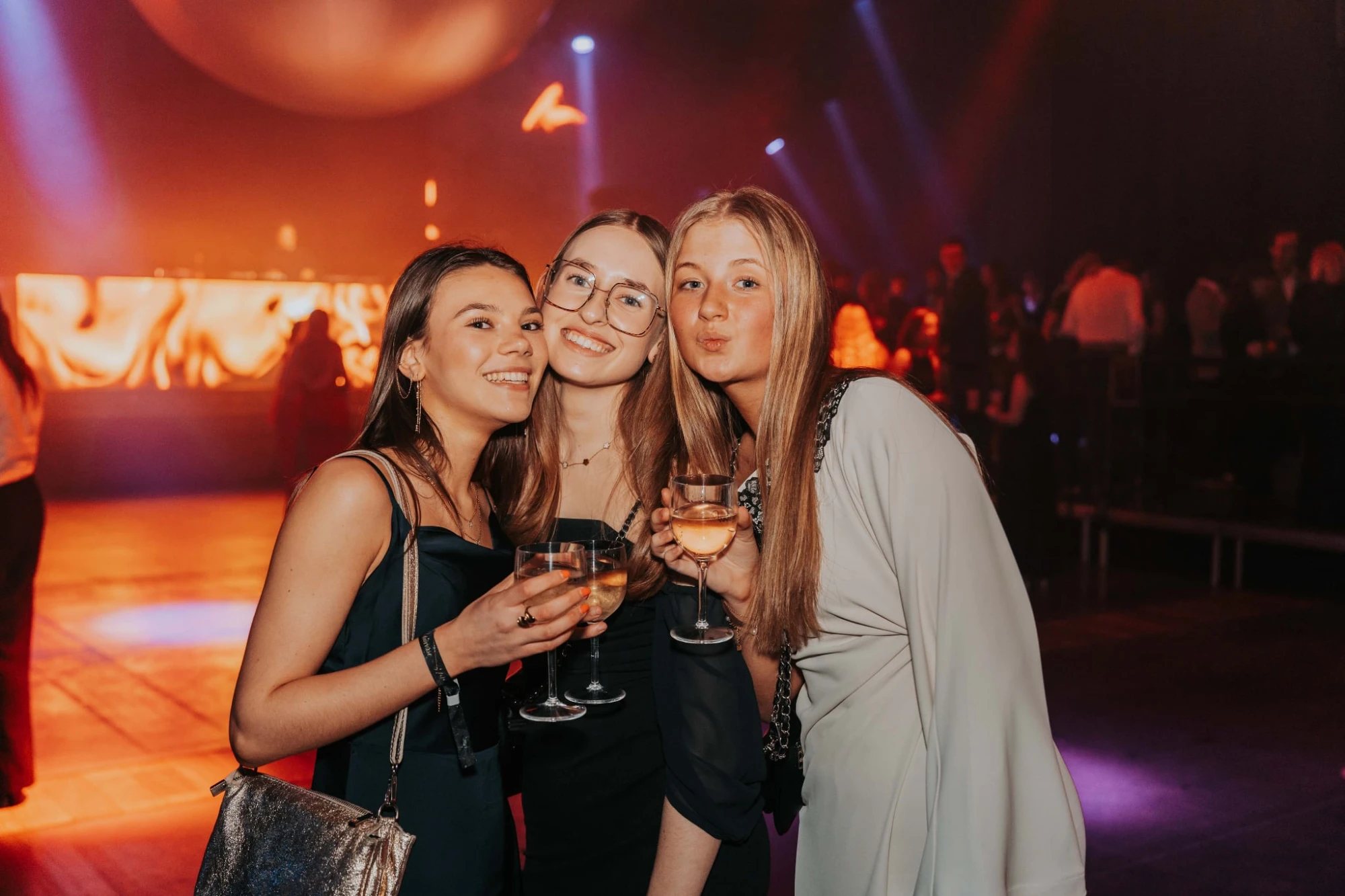 Drie vriendinnen met een glas op een feest