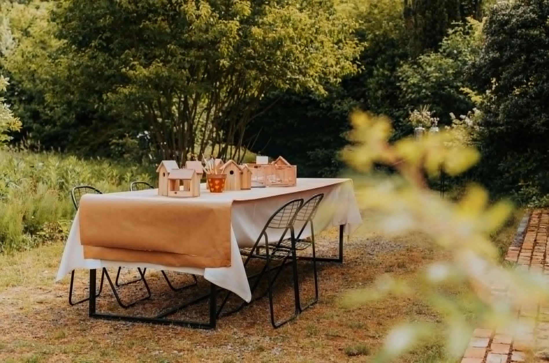Tafel met houten vogelhuisjes in een zomerse tuin