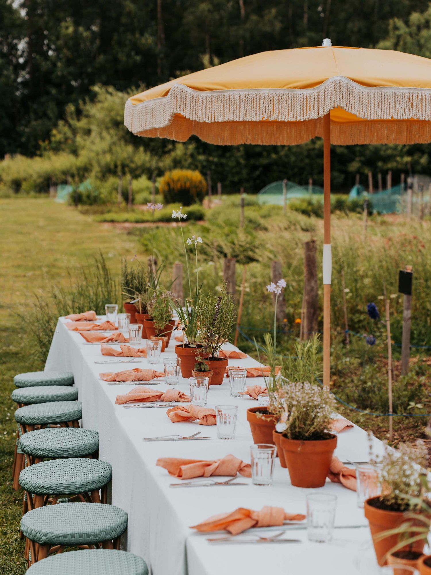 Lange tafel onder een parasol in een bloemenweide