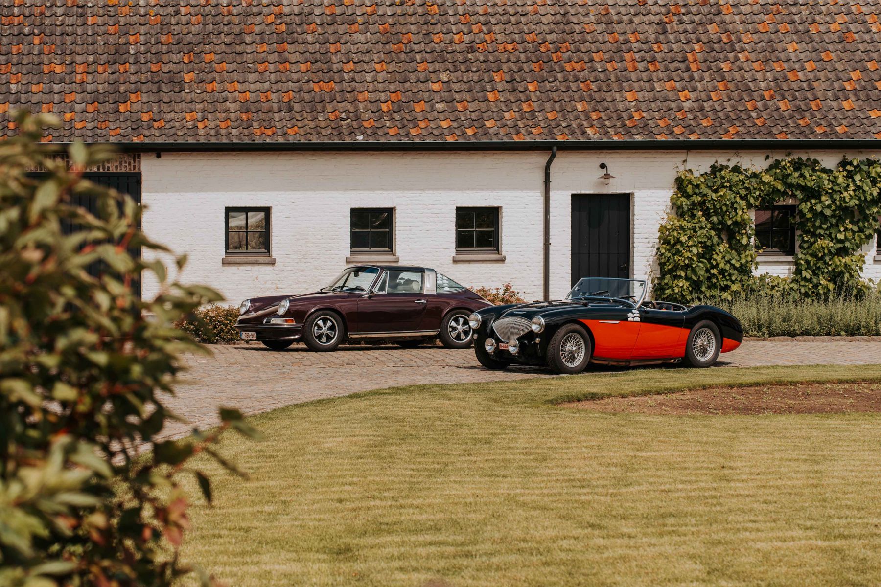 Oldtimers voor een witte hoeve