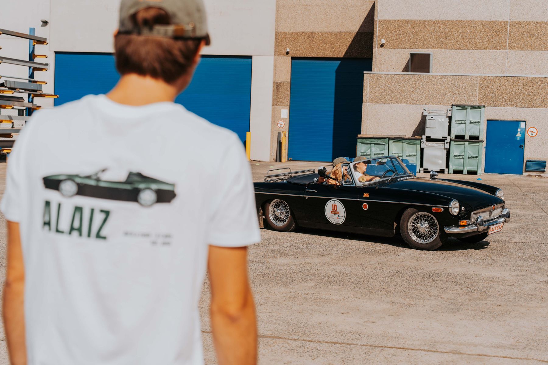Deelnemer in rally-shirt bij een oldtimer