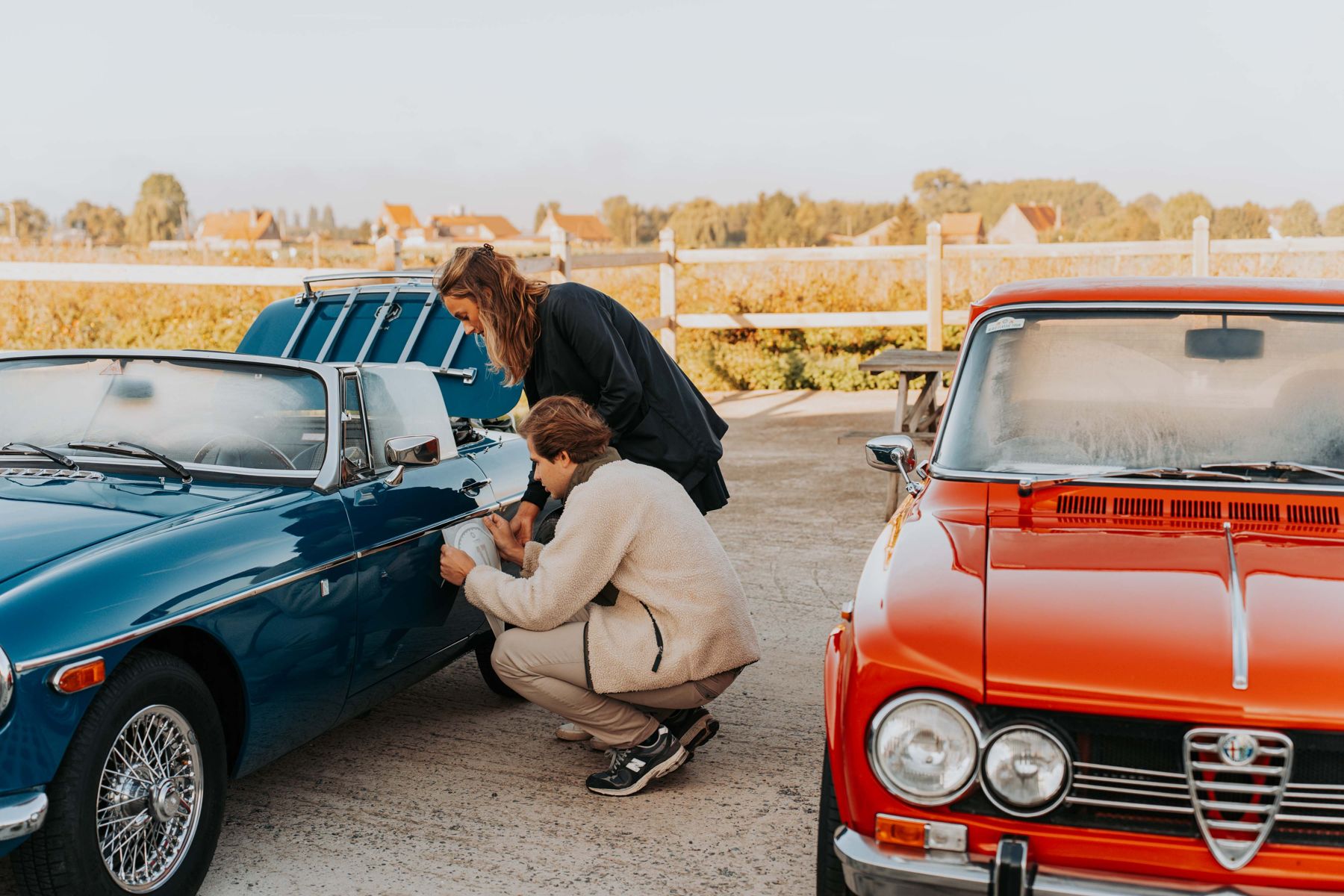 Blauwe en rode oldtimer naast elkaar