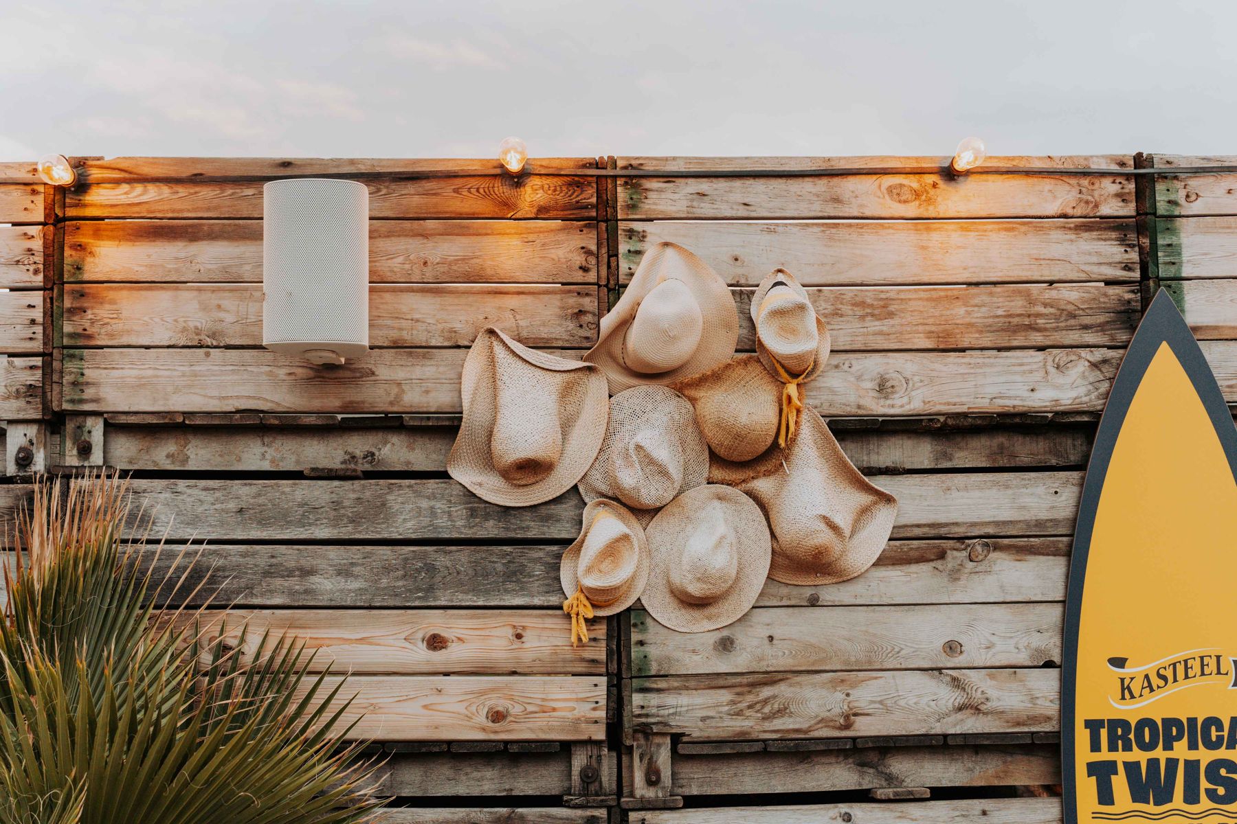 Strohoeden aan een houten wand