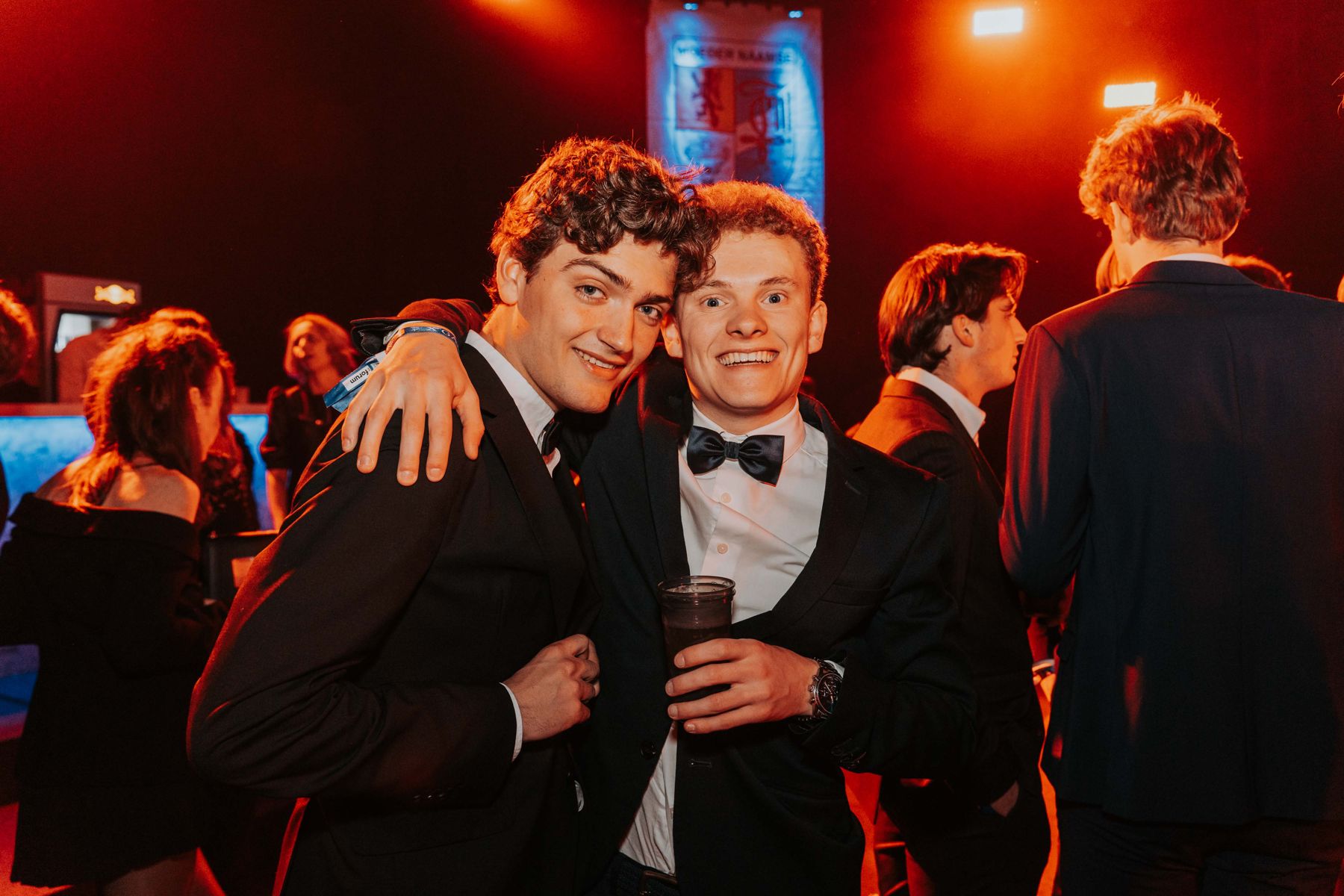 Vrienden in smoking poseren op een feest