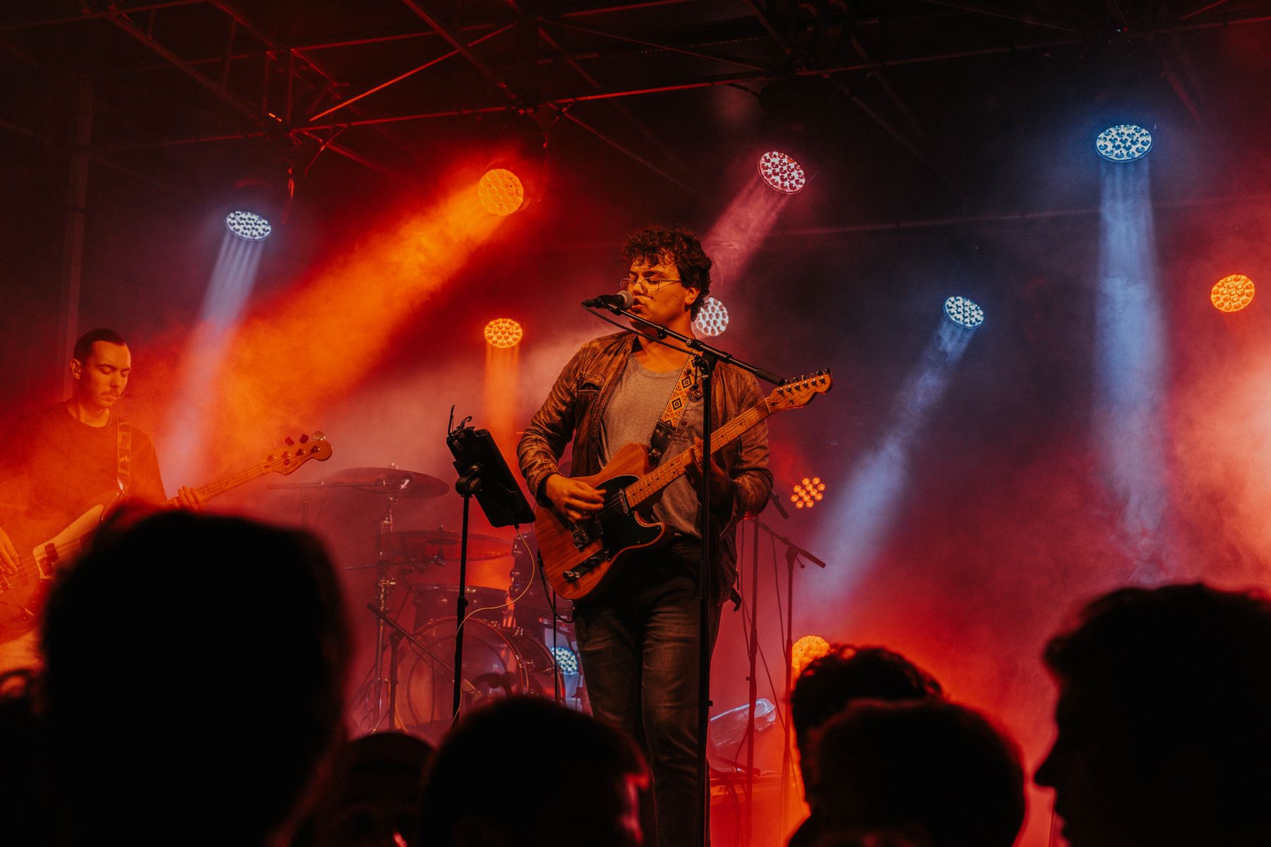 Zanger met gitaar in rood en blauw licht